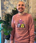 Man posing with arms at side in mauve Rebel Raw sweater.